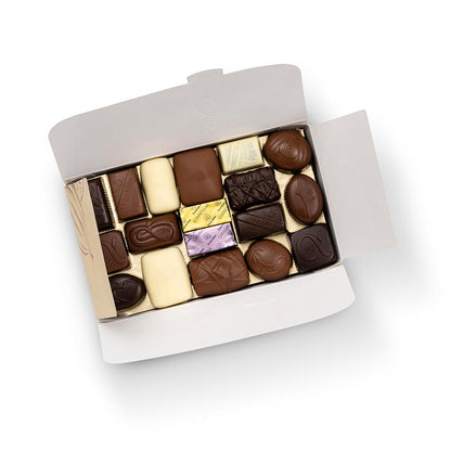 caixa dourada com bombons de chocolate sortidos da leonidas